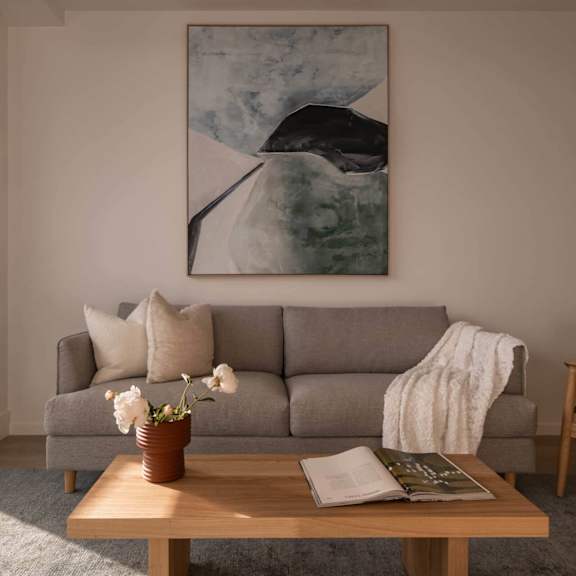 a living room with a table and a large picture on the wall