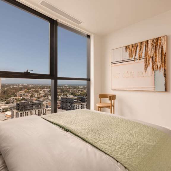 A bedroom with a large bed and a view of the city.