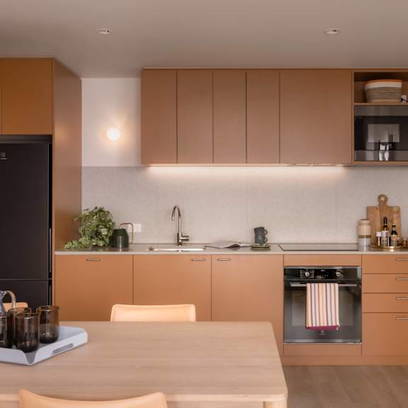A modern kitchen with wooden cabinets and a wooden table.