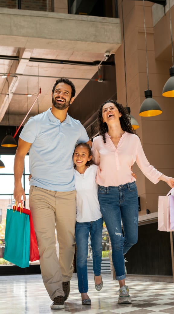 happy family walking through the lobby with shopping bags