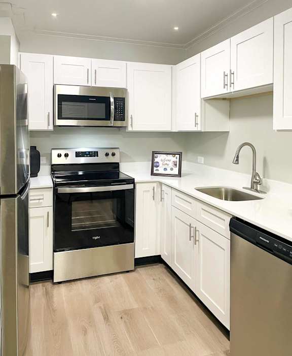 A kitchen with white cabinets and stainless steel appliances.