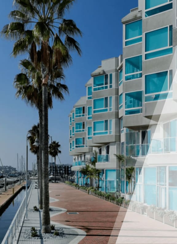the facade of a building with palm trees and a boardwalk