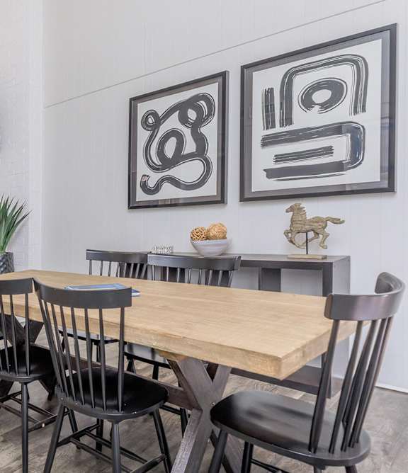 a dining room with a table and chairs and paintings on the wall