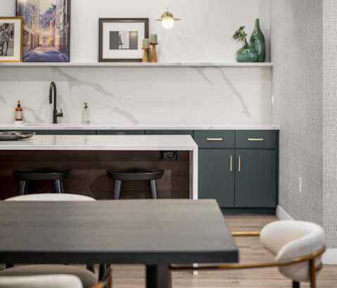 A modern dining area with a table, chairs, and a shelf with decorative items.