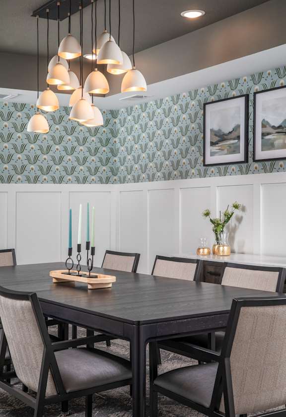 A dining table with chairs and a candle holder on top of it.