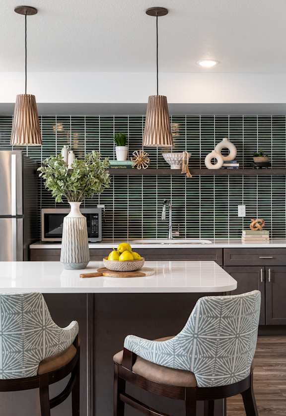 a kitchen with a white counter top and three chairs