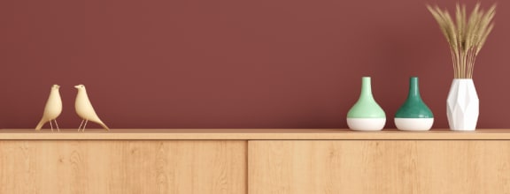 a sideboard with three vases and a plant on it