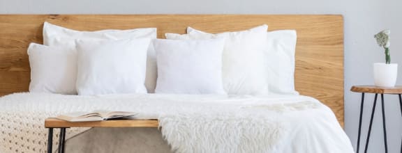 a bed with white pillows and a wooden headboard