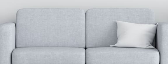 a gray couch with a white pillow in a living room