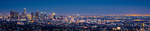 A cityscape at night with buildings illuminated against a dark sky.