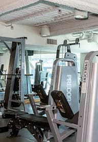 A gym with a variety of exercise equipment including treadmills, weights, and exercise machines.