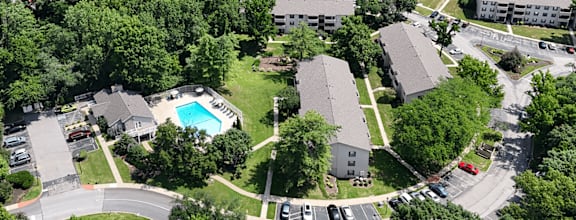 A bird's eye view of a residential area with a swimming pool.