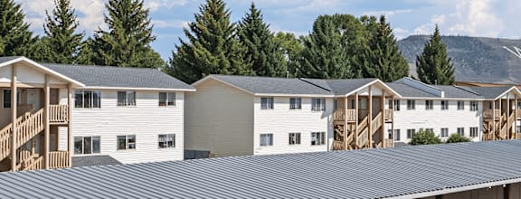 A series of white houses with balconies are lined up in a row.