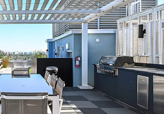A patio with a table and chairs overlooking a city.