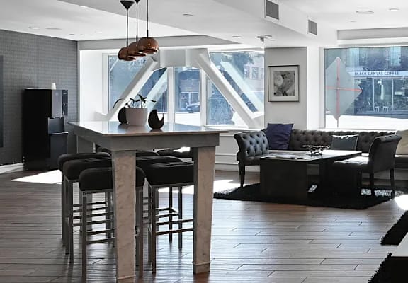 A modern living room with a bar area and a view of the city.