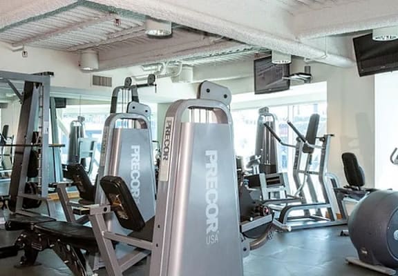 A gym with a variety of exercise equipment including treadmills, weights, and exercise machines.