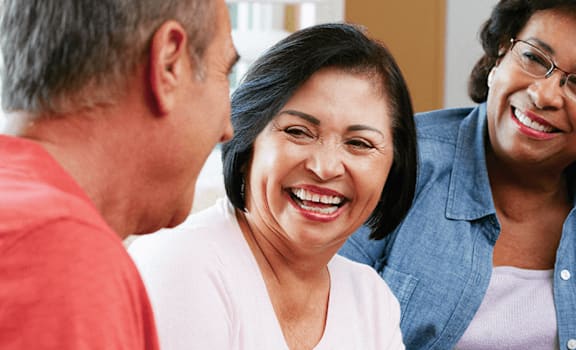 A group of four people are laughing together.