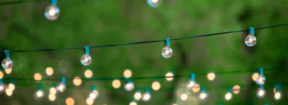 A string of light bulbs are hanging on a wire.