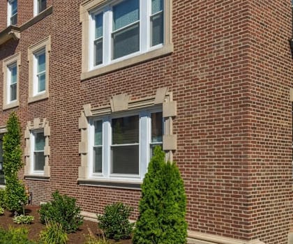 A row of red brick townhouses with white trim and windows.