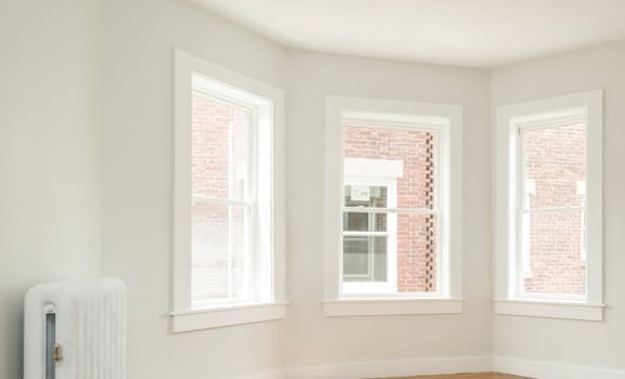 A white room with a window and a radiator.