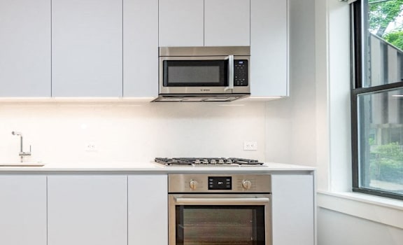 A modern kitchen with a microwave oven mounted above a stove.