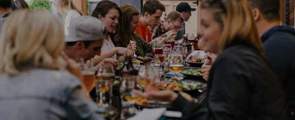 a group of people sitting around a table eating food
