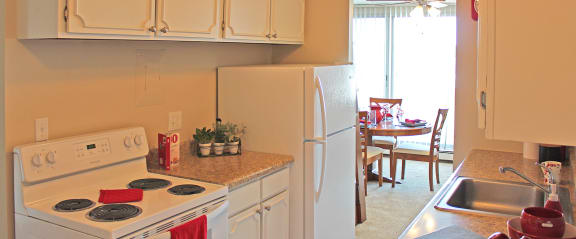 a kitchen with white appliances and a sink and a refrigerator