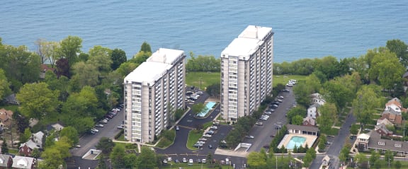 an aerial view of two tall buildings near the water