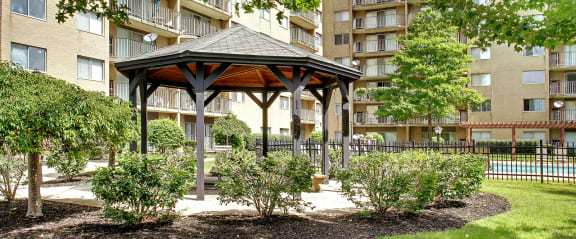a gazebo in a park next to an apartment building