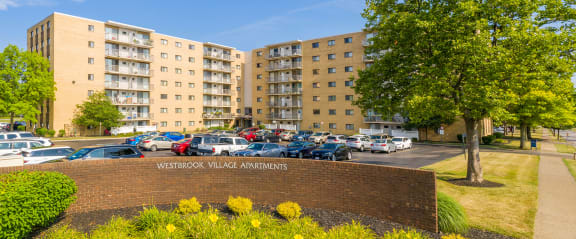 a brick building with a parking lot with cars in front of it