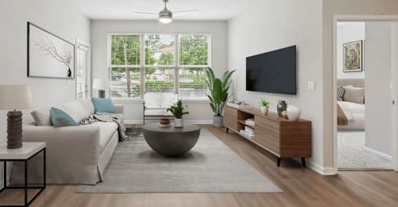 A modern living room with a grey sofa, a black TV, and a large window at Two Addison Place, Pooler, GA, 31322