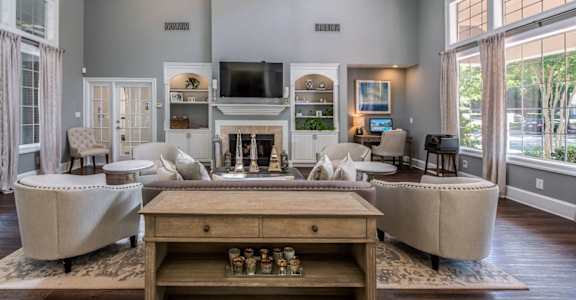 A living room with a fireplace and a couch at The Village Apartments, Raleigh