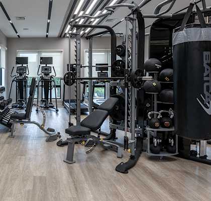 a spacious fitness room filled with exercise bikes and weights