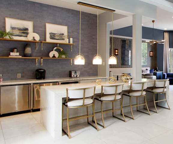 A modern kitchen with a breakfast bar and a living room area.