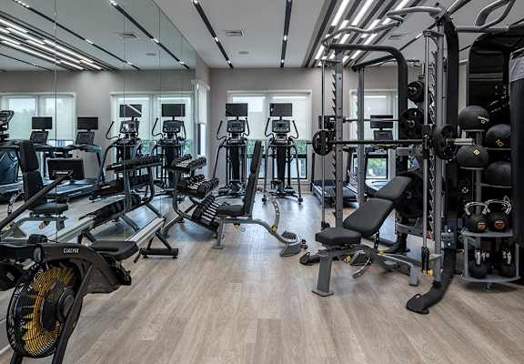 a spacious fitness room filled with exercise bikes and weights