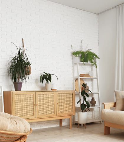 A living room with a white brick wall and a wooden chair.
