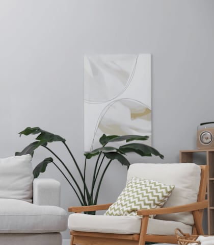A living room with a white couch, a wooden chair, a wooden table, and a potted plant.
