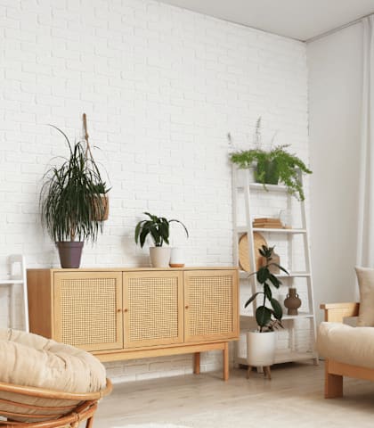 A living room with a white brick wall and a wooden chair.