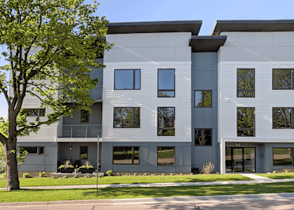 a white and gray building with trees in front of it