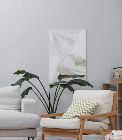 A living room with a white couch, a wooden chair, a wooden table, and a potted plant.