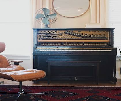 a leather chair sits in front of a piano