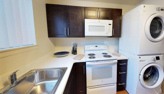 A small kitchen with a washer and dryer stacked on top of each other. at Somerset at Towson Apartments, Towson, MD, 21204