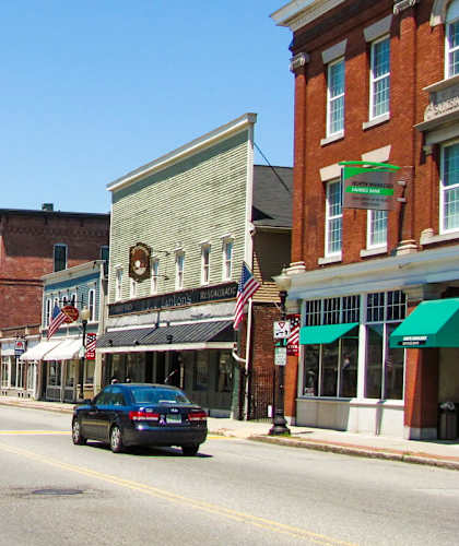 A street in a small town with American flags hanging from lamp posts.