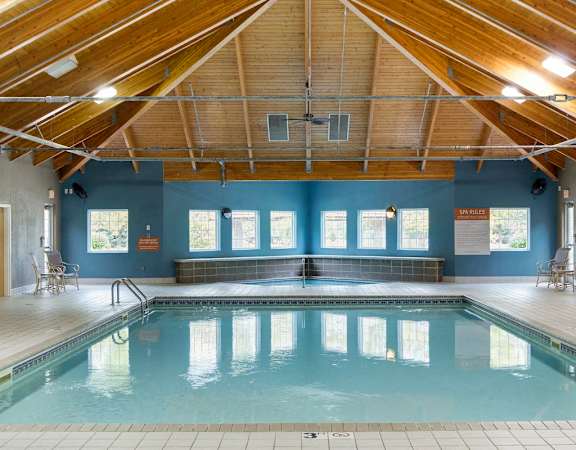 A large indoor swimming pool with a wooden ceiling.