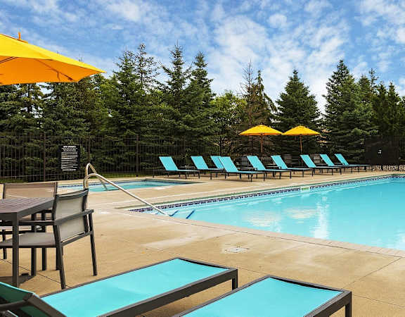 a swimming pool with chairs and umbrellas at the resort  at Shadow Hills, Plymouth, Minnesota
