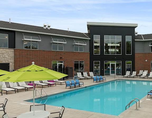 A large swimming pool surrounded by lounge chairs and umbrellas at Era on Excelsior, St. Louis Park, Minnesota
