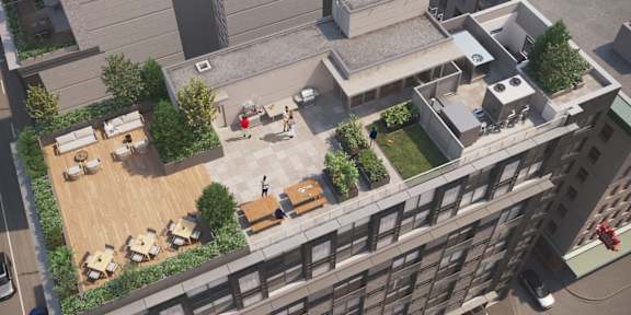 A top-down view of a courtyard with tables and chairs surrounded by buildings.
