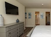 Thumbnail 6 of 11 - A bedroom with a large bed and a tv mounted on the wall at Deer Park Apartments, Randallstown, 21133