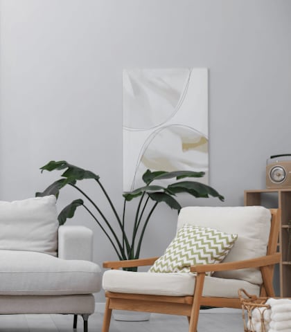 A living room with a white couch, a wooden chair, a wooden table, and a potted plant.