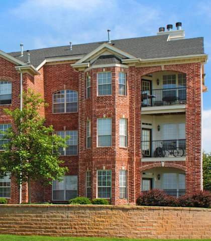 A red brick building with a green lawn in front.